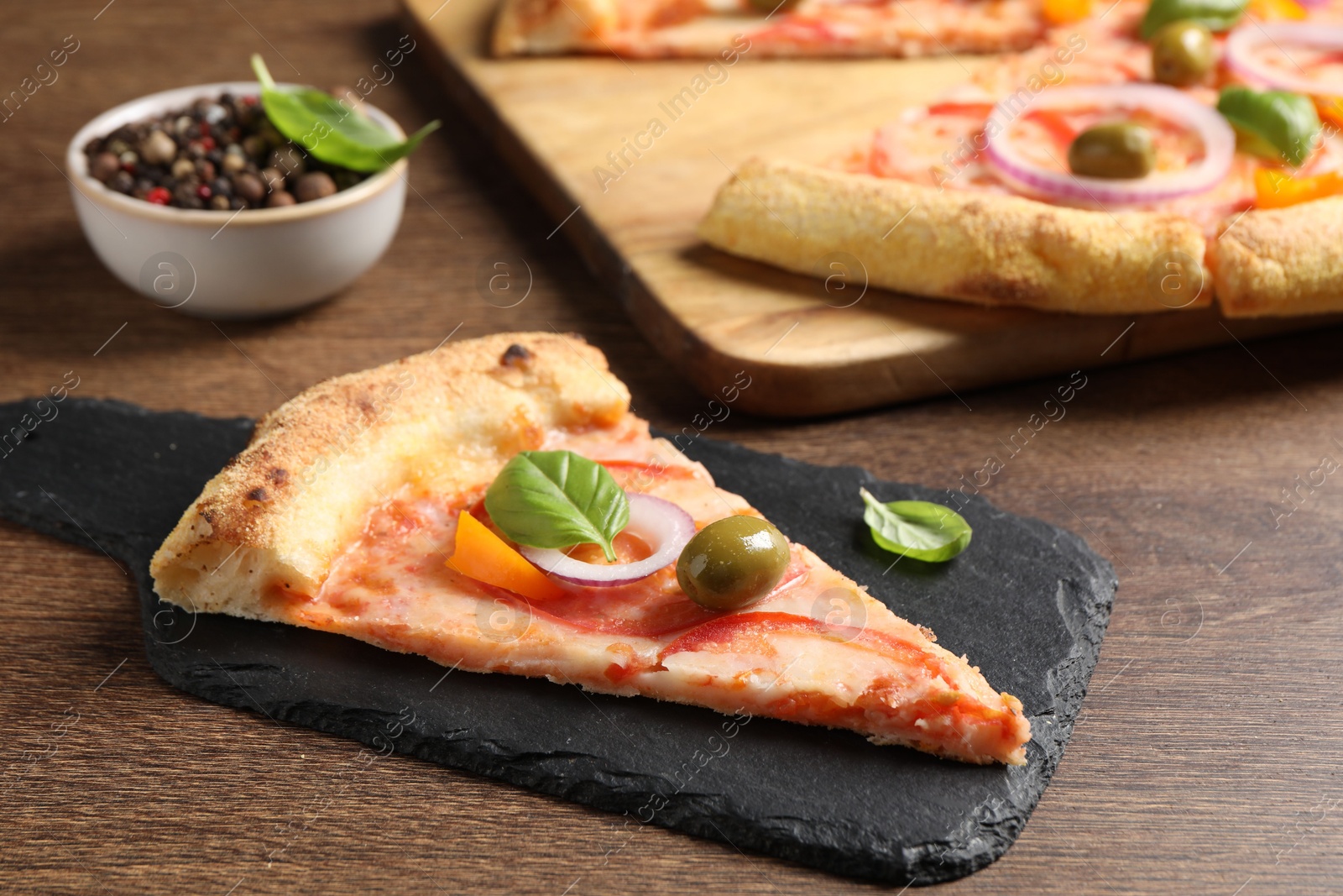 Photo of Slice of delicious vegetarian pizza on wooden table, closeup