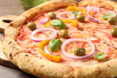 Photo of Cut delicious vegetarian pizza on wooden table, closeup