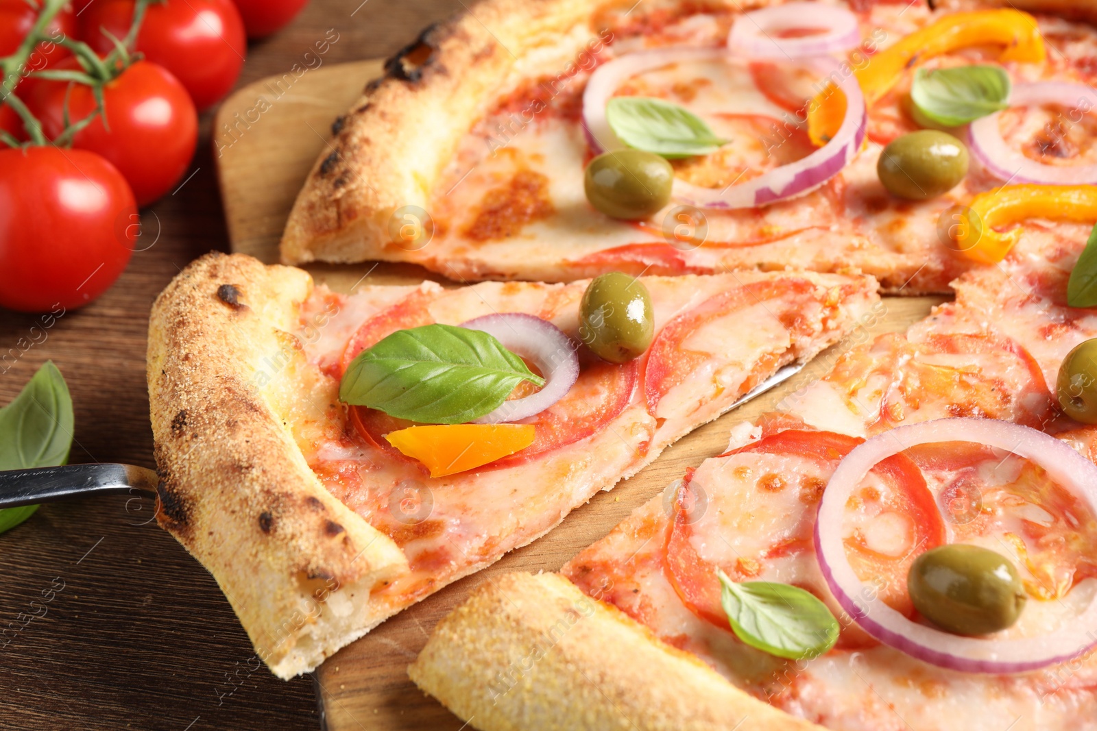 Photo of Cut delicious vegetarian pizza on wooden table, closeup