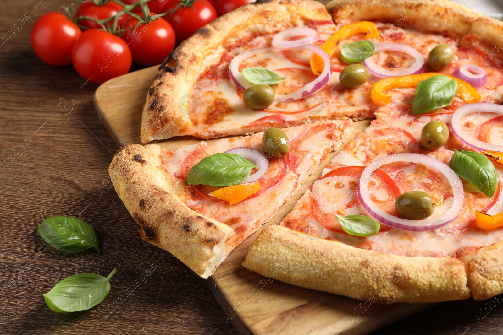 Photo of Cut delicious vegetarian pizza on wooden table, closeup