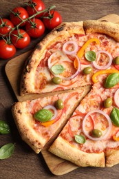 Photo of Delicious vegetarian pizza and tomatoes on wooden table, flat lay