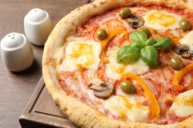 Photo of Delicious vegetarian pizza on wooden table, closeup