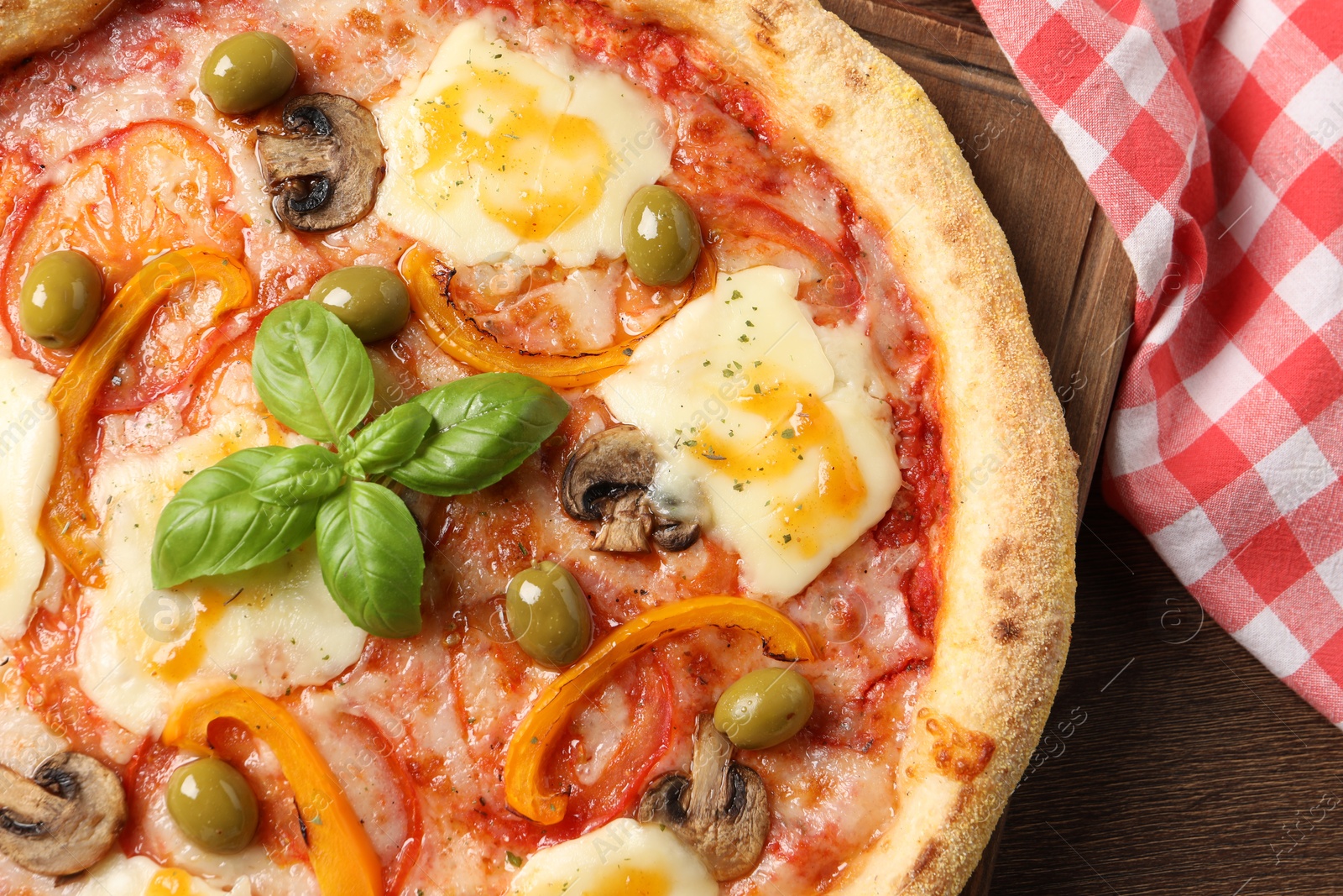 Photo of Delicious vegetarian pizza on wooden table, top view