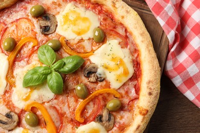 Photo of Delicious vegetarian pizza on wooden table, top view