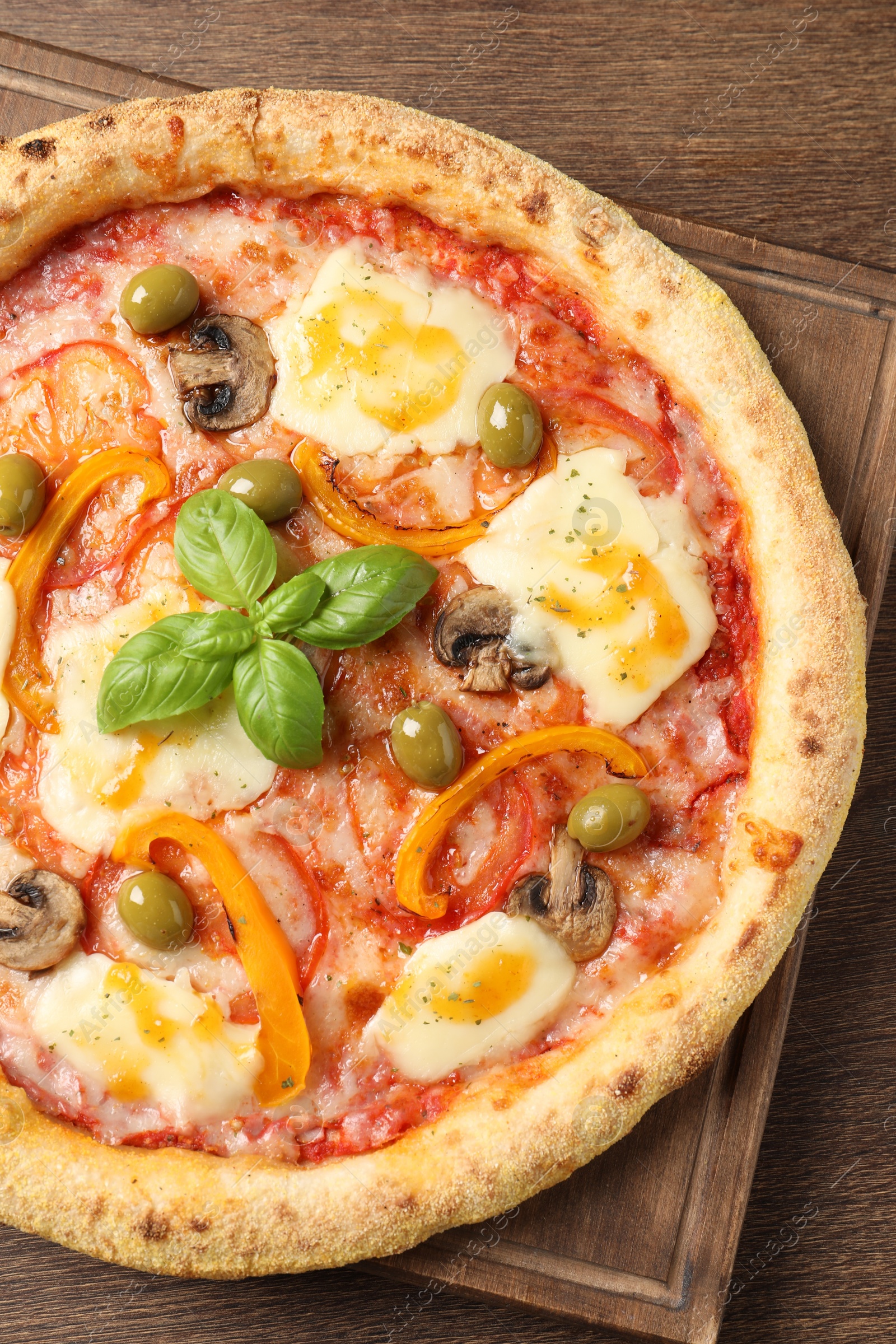 Photo of Delicious vegetarian pizza on wooden table, top view