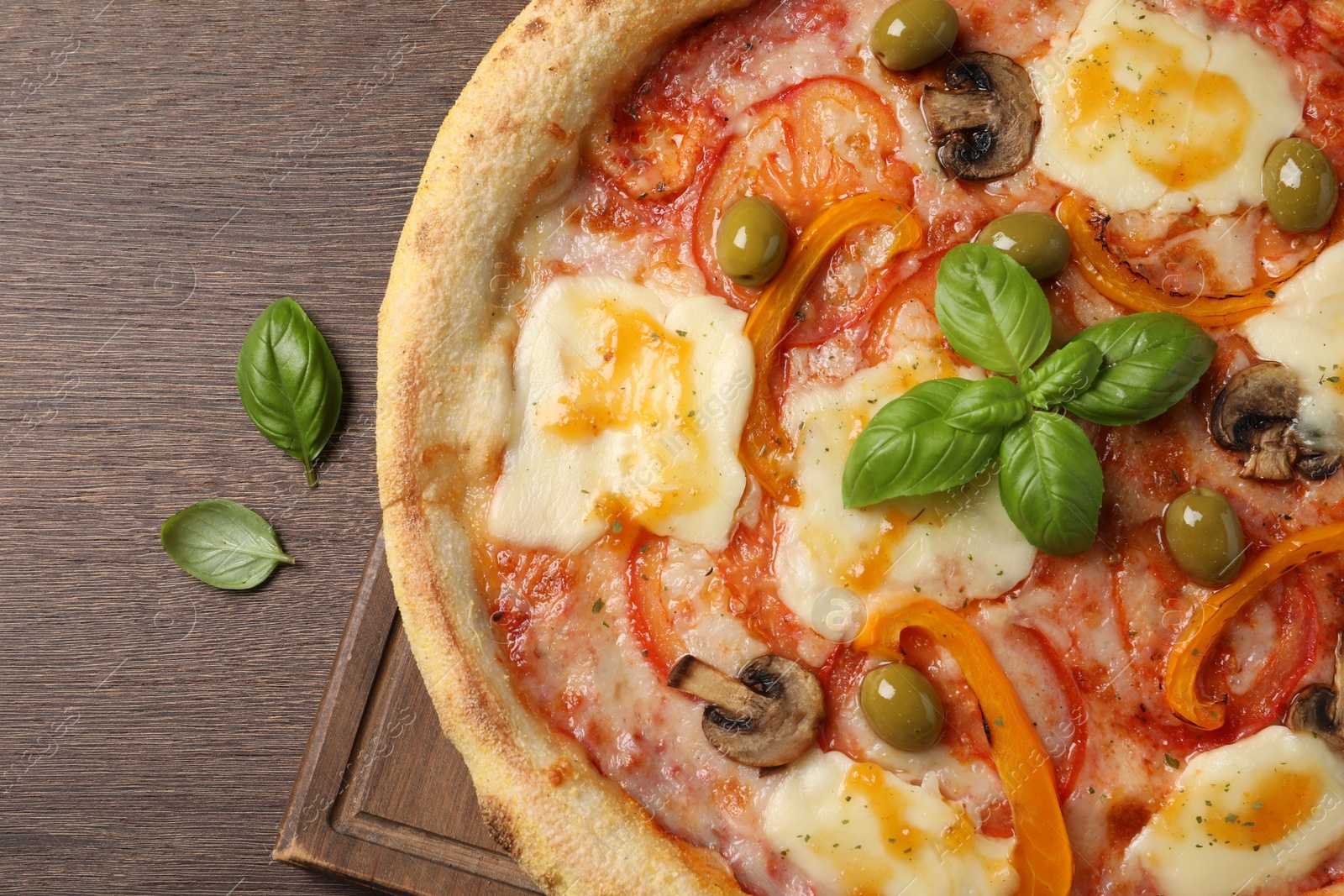 Photo of Delicious vegetarian pizza on wooden table, top view