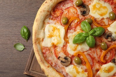 Photo of Delicious vegetarian pizza on wooden table, top view