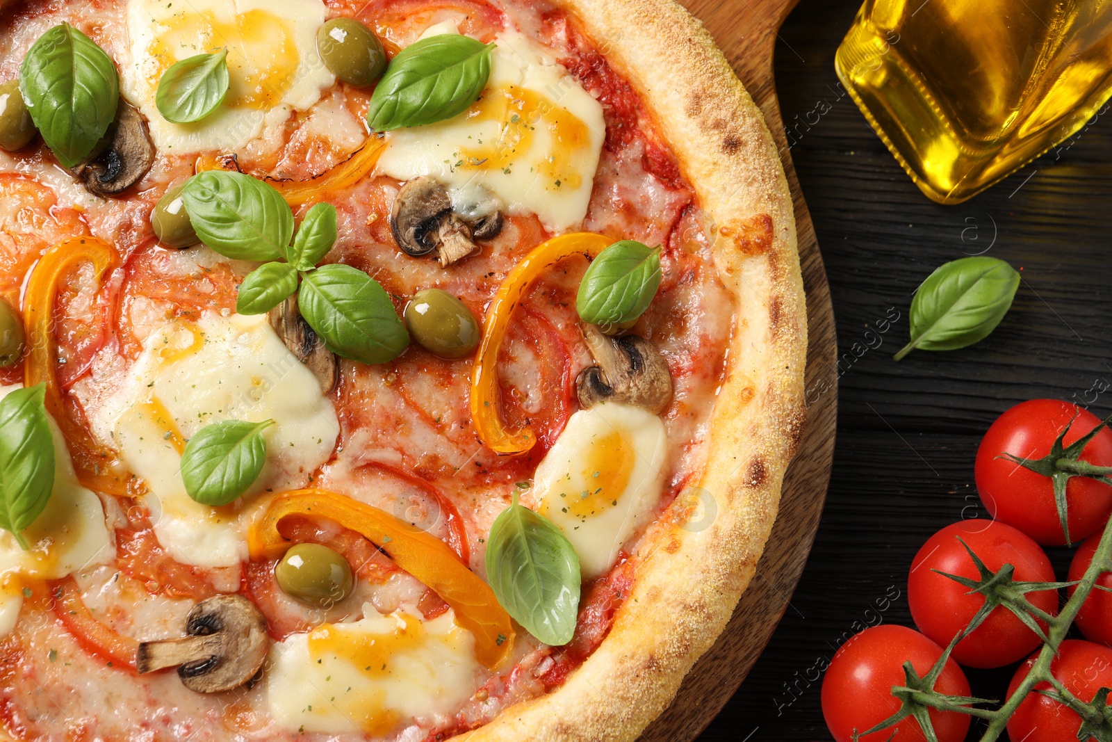 Photo of Delicious vegetarian pizza on black wooden table, closeup