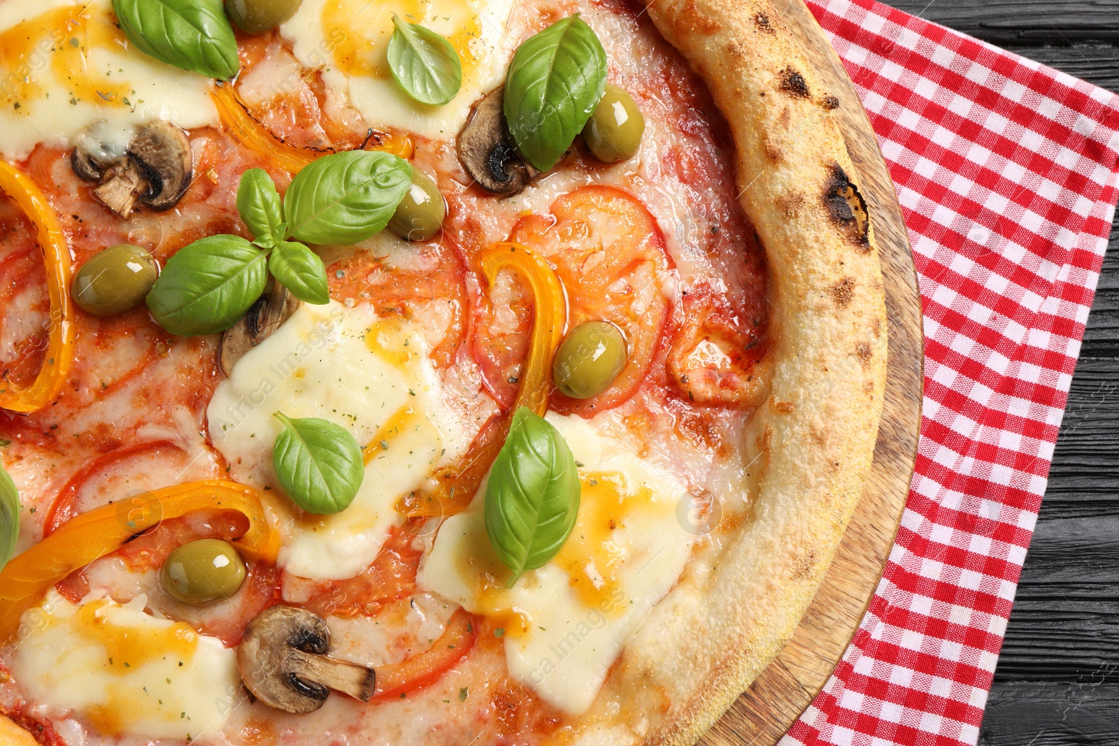 Photo of Delicious vegetarian pizza on black wooden table, closeup