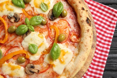 Photo of Delicious vegetarian pizza on black wooden table, closeup