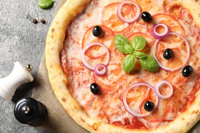 Photo of Delicious vegetarian pizza on grey table, top view