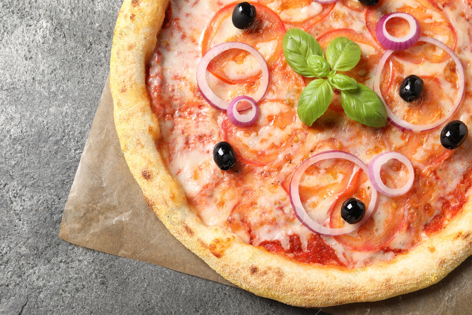 Photo of Delicious vegetarian pizza on grey table, top view