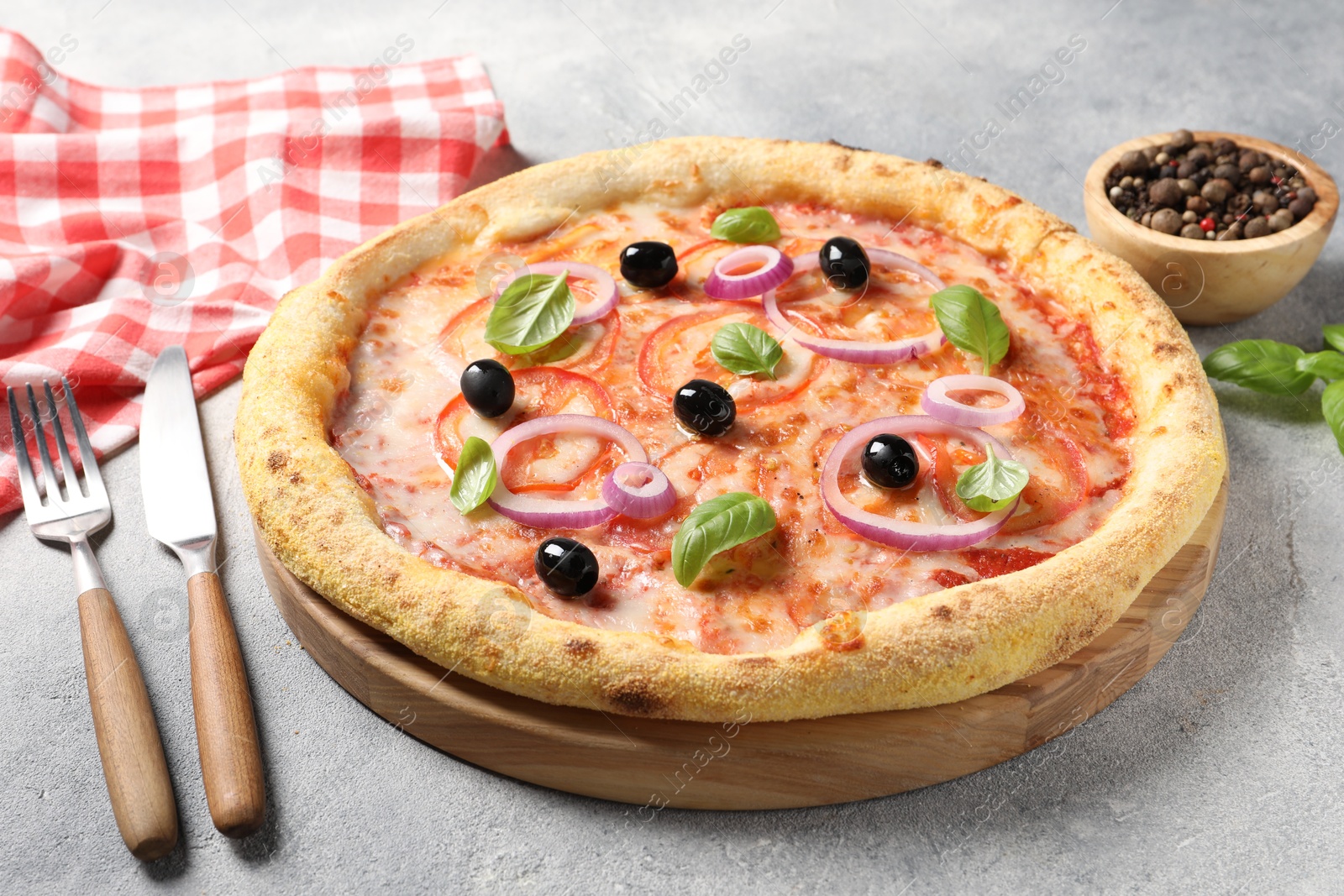 Photo of Delicious vegetarian pizza, peppercorns and cutlery on light grey table