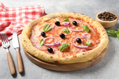 Photo of Delicious vegetarian pizza, peppercorns and cutlery on light grey table