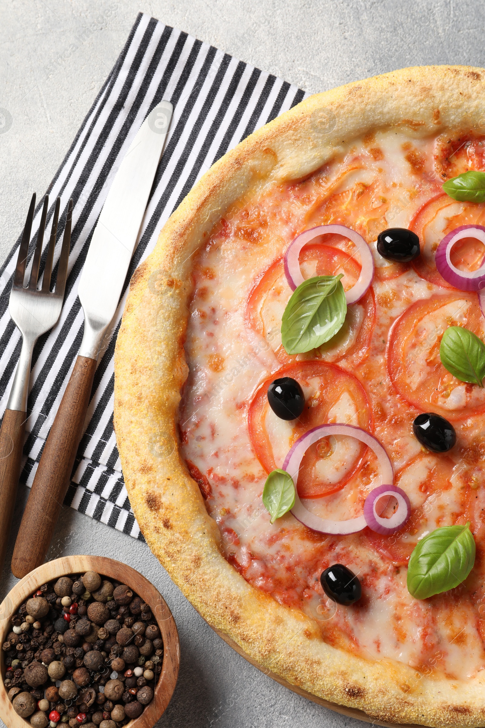 Photo of Delicious vegetarian pizza, peppercorns and cutlery on light grey table, top view