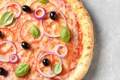 Photo of Delicious vegetarian pizza on light grey table, top view