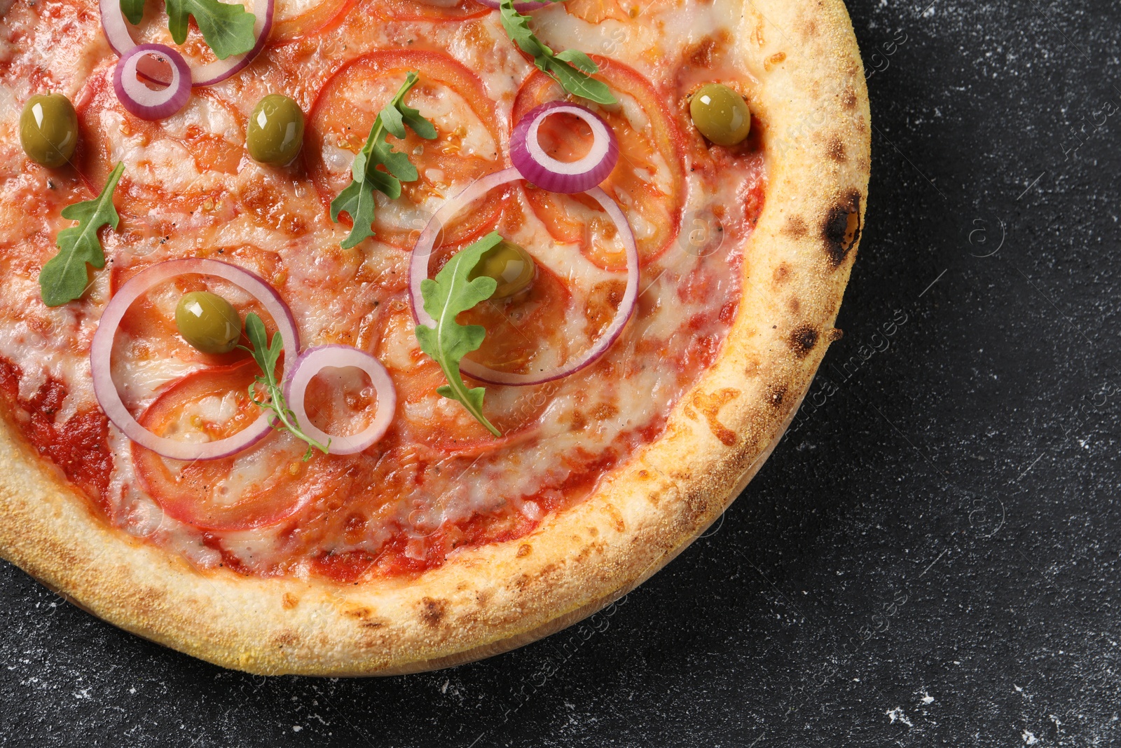 Photo of Delicious vegetarian pizza on black table, top view