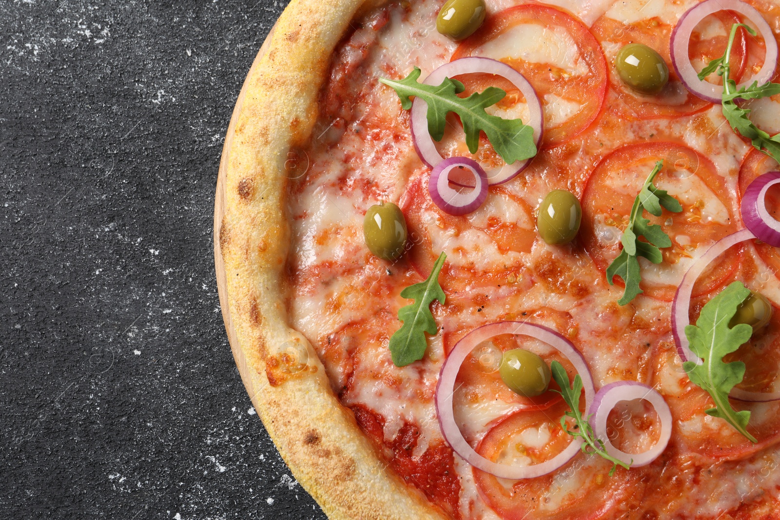 Photo of Delicious vegetarian pizza on black table, top view