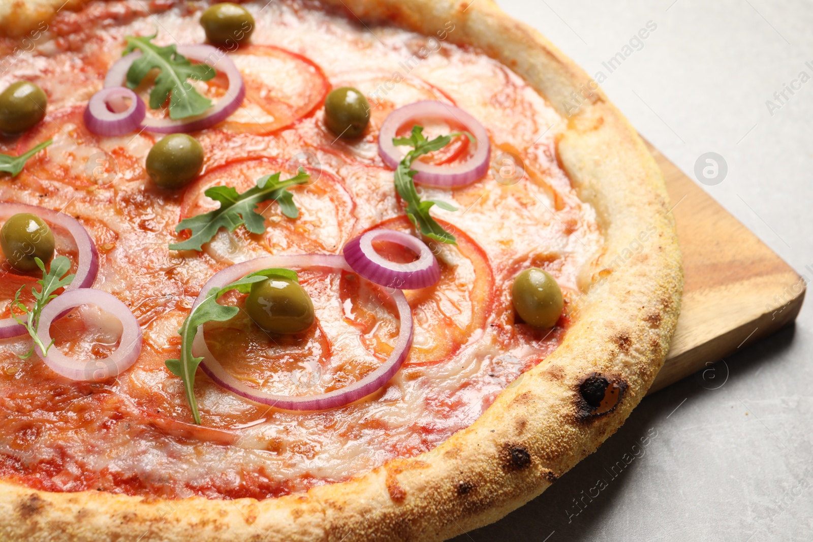 Photo of Delicious vegetarian pizza on light grey background, closeup