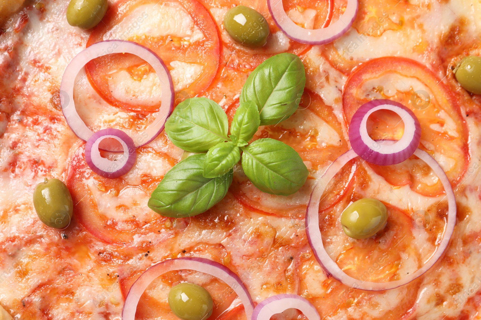 Photo of Delicious vegetarian pizza with basil as background, closeup