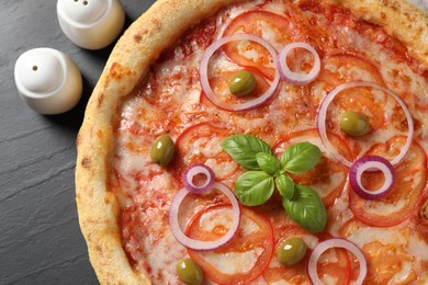 Photo of Delicious vegetarian pizza on black table, top view