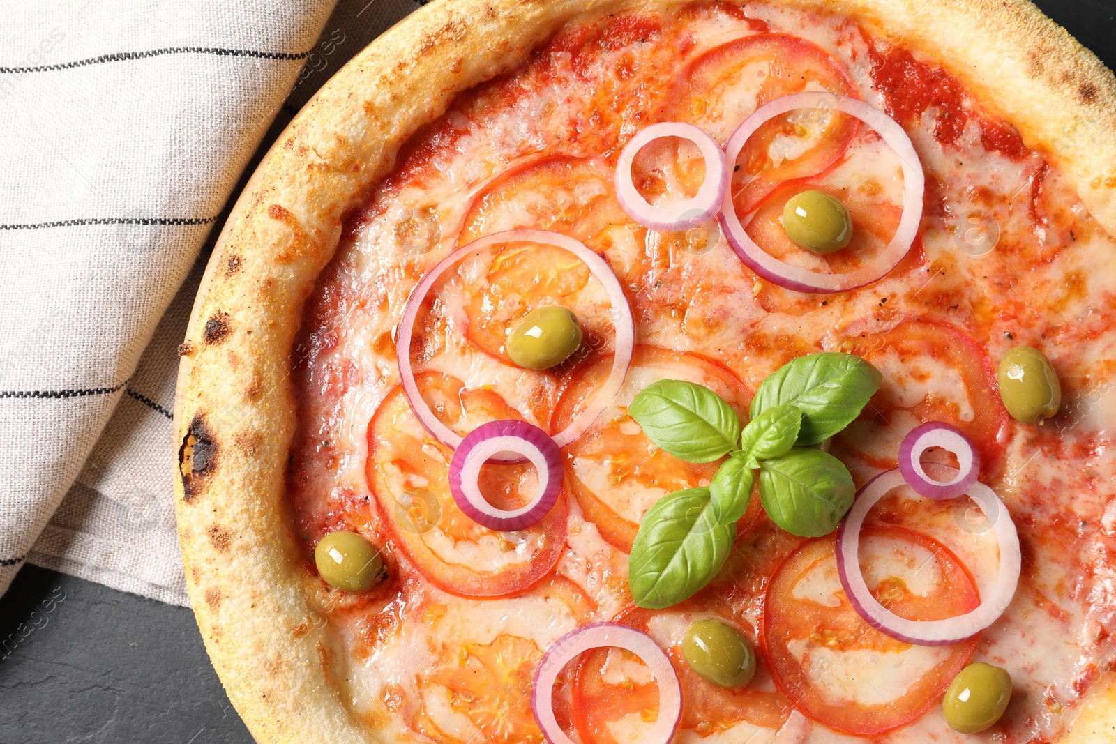 Photo of Delicious vegetarian pizza on black table, top view