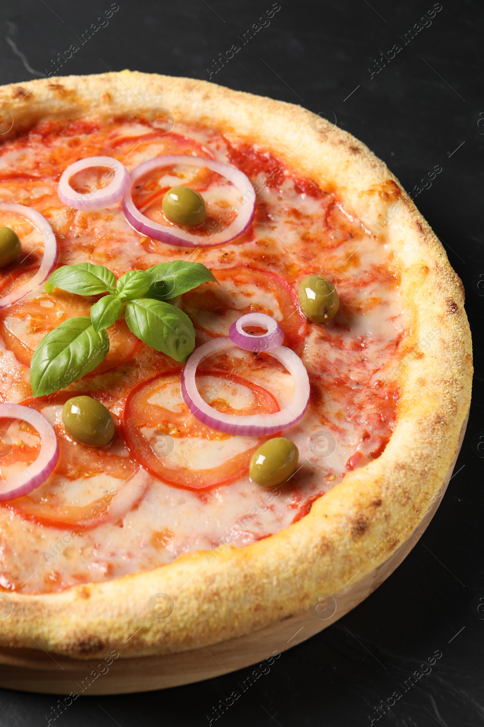 Photo of Delicious vegetarian pizza on black table, closeup