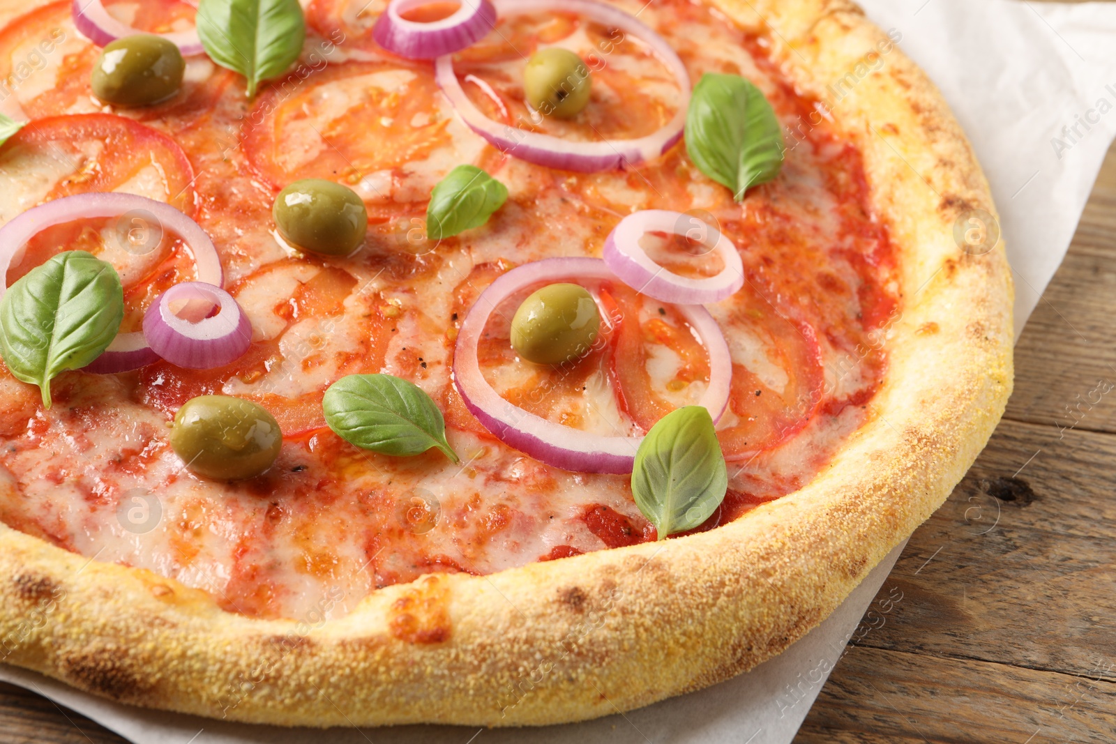 Photo of Delicious vegetarian pizza on wooden table, closeup