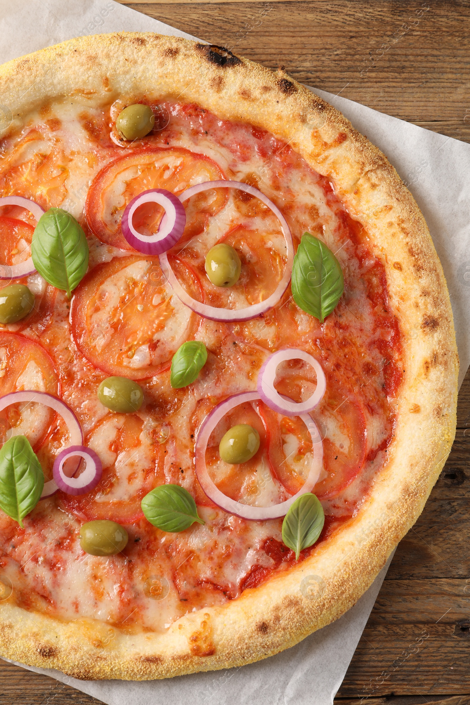 Photo of Delicious vegetarian pizza on wooden table, top view