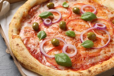 Photo of Delicious vegetarian pizza in box on black table, closeup