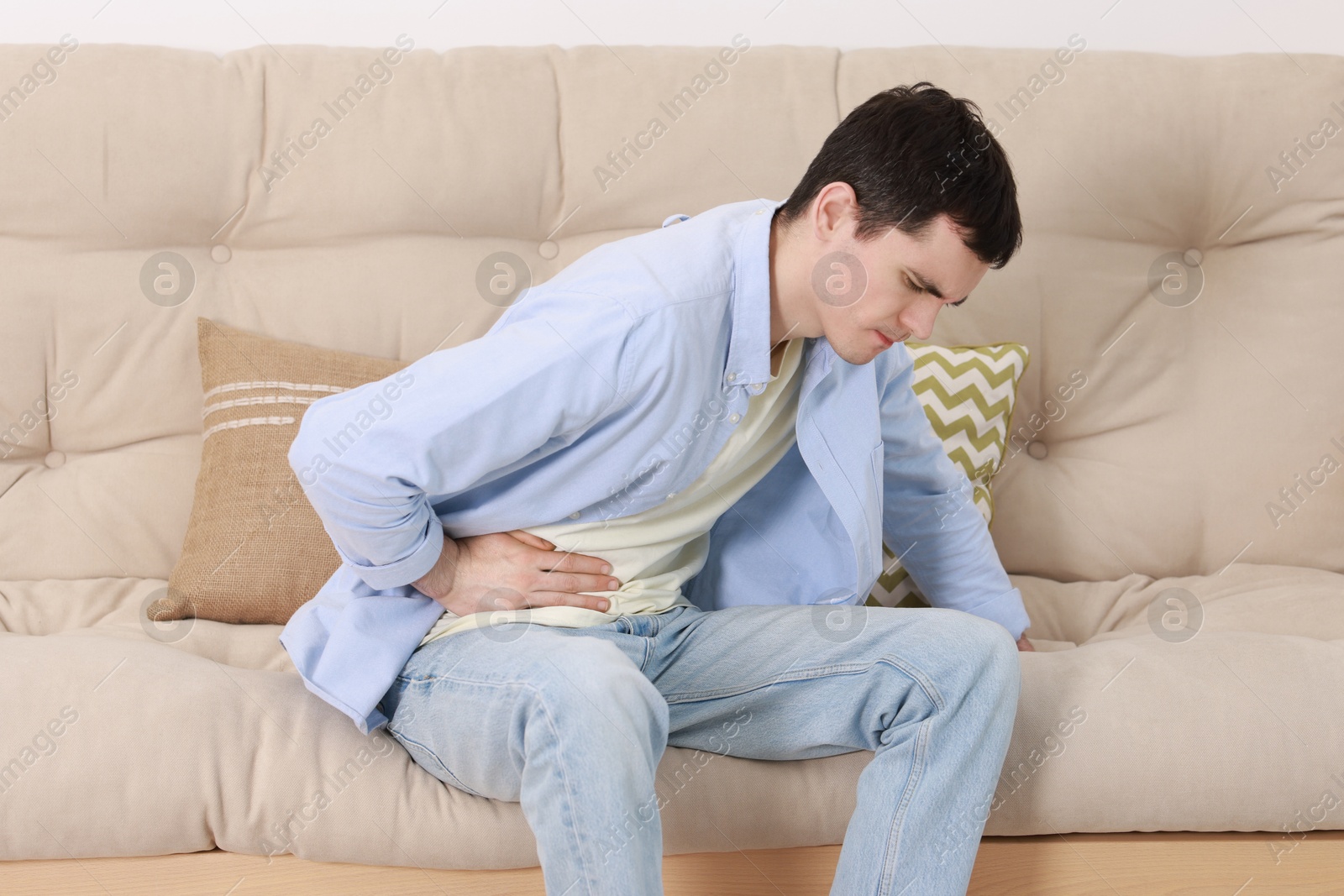 Photo of Man suffering from abdominal pain at home