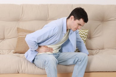 Man suffering from abdominal pain at home