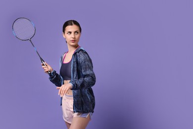 Young woman with badminton racket on purple background, space for text
