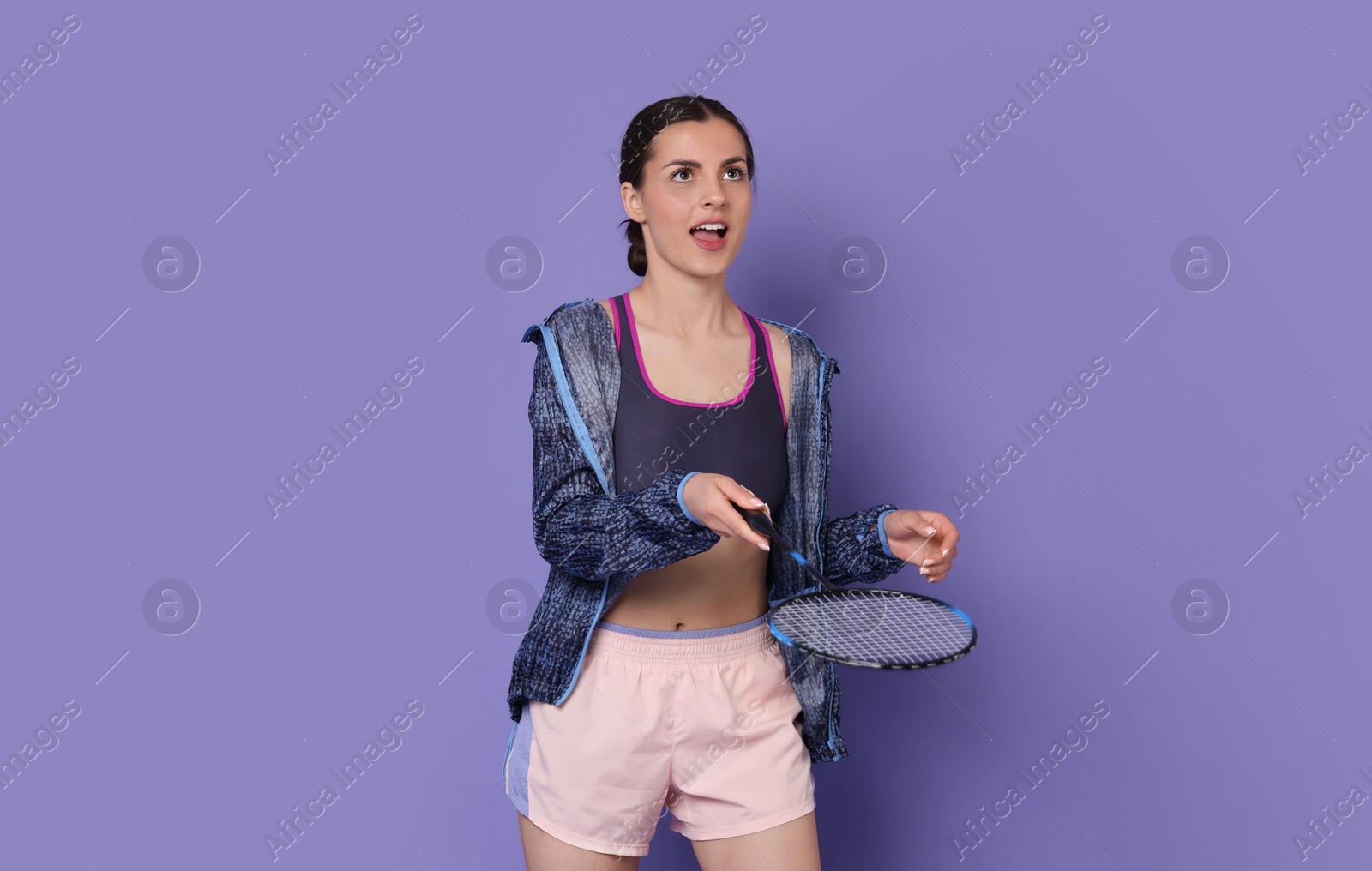 Photo of Young woman with badminton racket on purple background