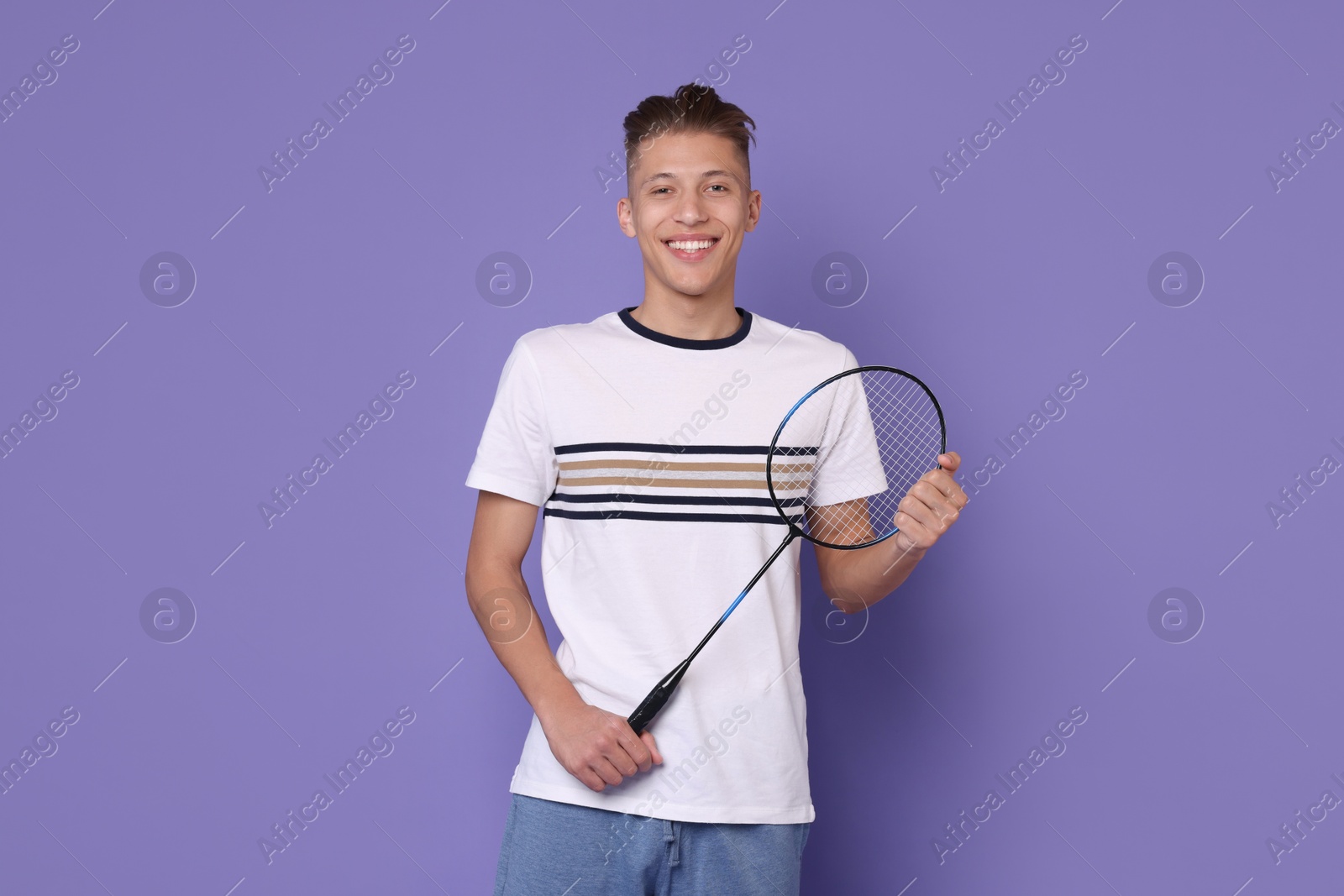 Photo of Young man with badminton racket on purple background