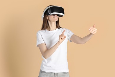 Photo of Smiling woman using virtual reality headset on beige background