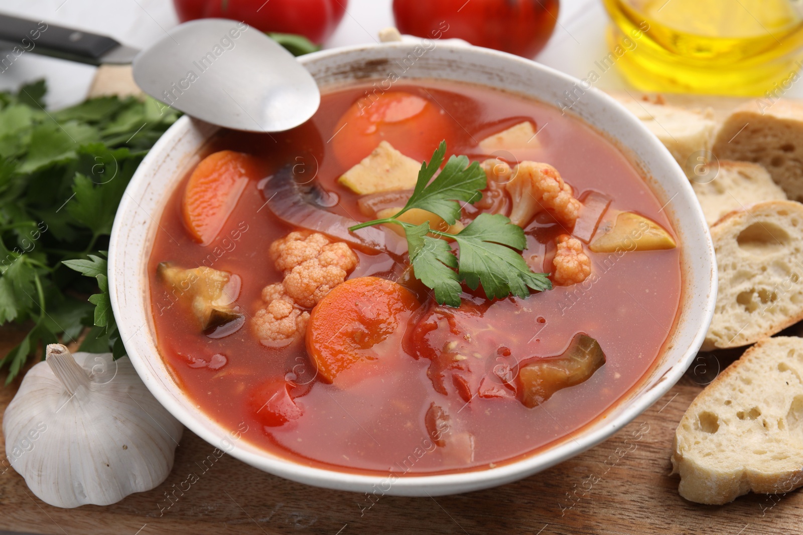 Photo of Delicious homemade stew in bowl and bread on table, closeup