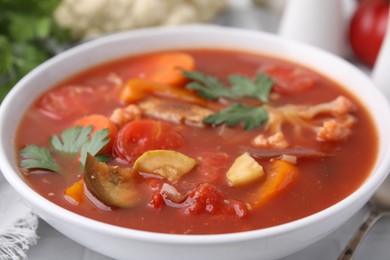 Photo of Delicious homemade stew in bowl on white table, closeup