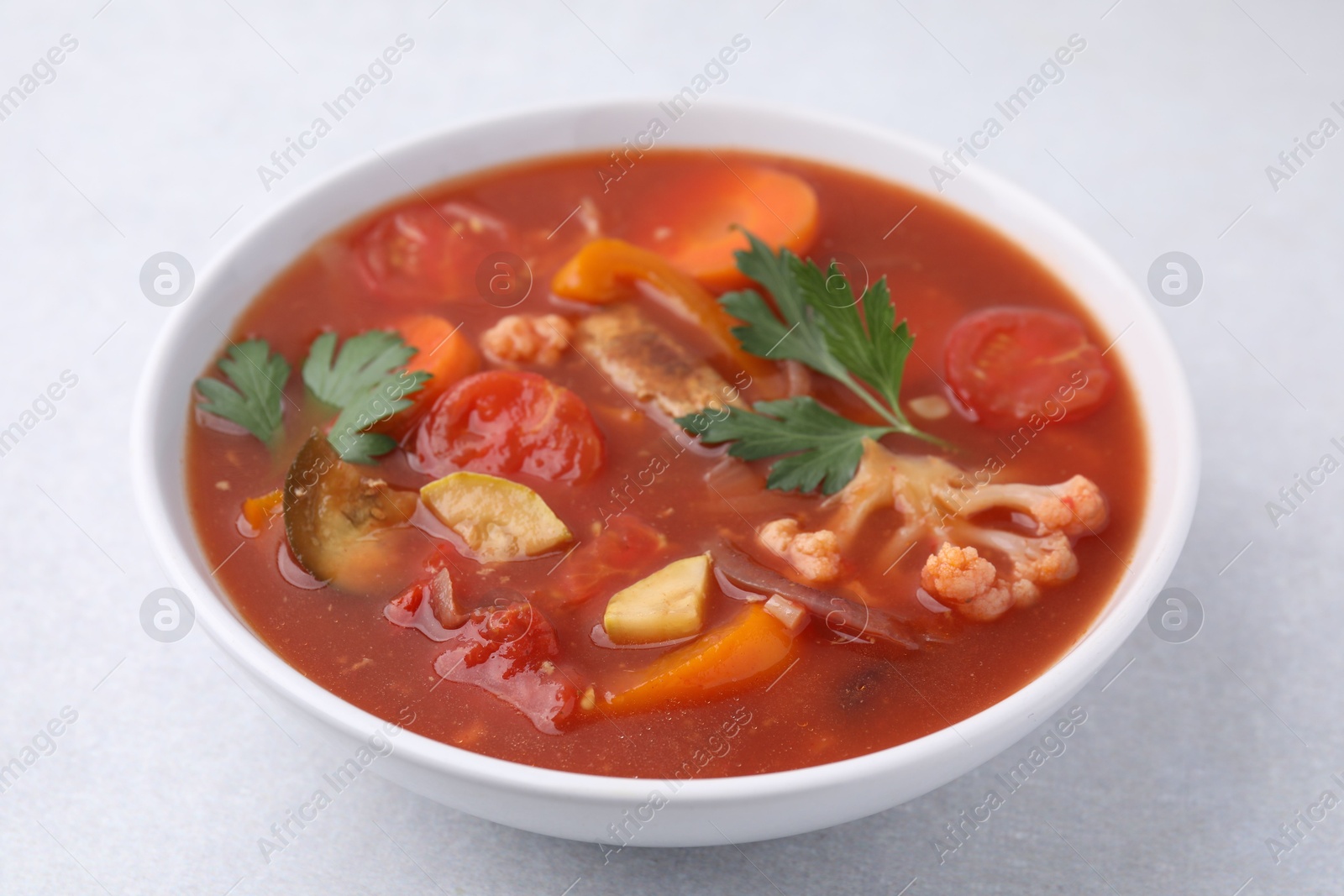 Photo of Delicious homemade stew in bowl on light table, closeup