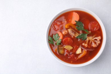 Photo of Delicious homemade stew in bowl on light table, top view. Space for text