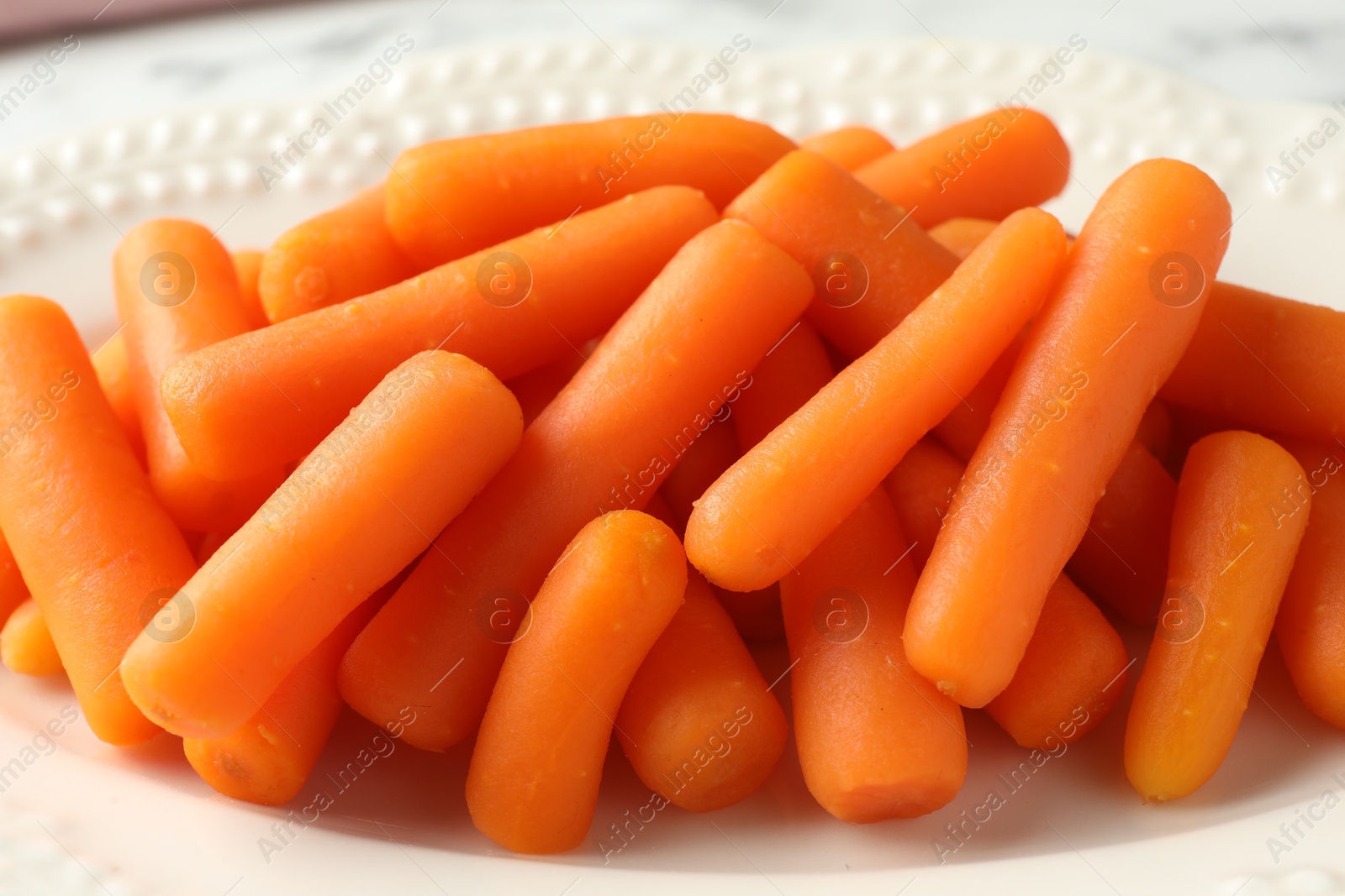 Photo of Many baby carrots on plate, closeup view