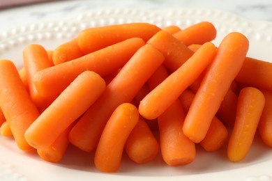 Many baby carrots on plate, closeup view