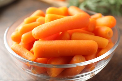 Baby carrots in bowl on table, closeup