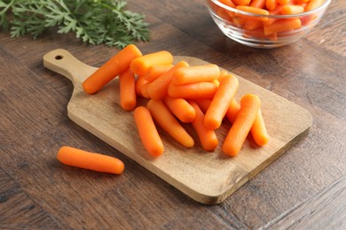 Baby carrots green leaves on wooden table