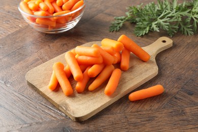 Photo of Baby carrots green leaves on wooden table