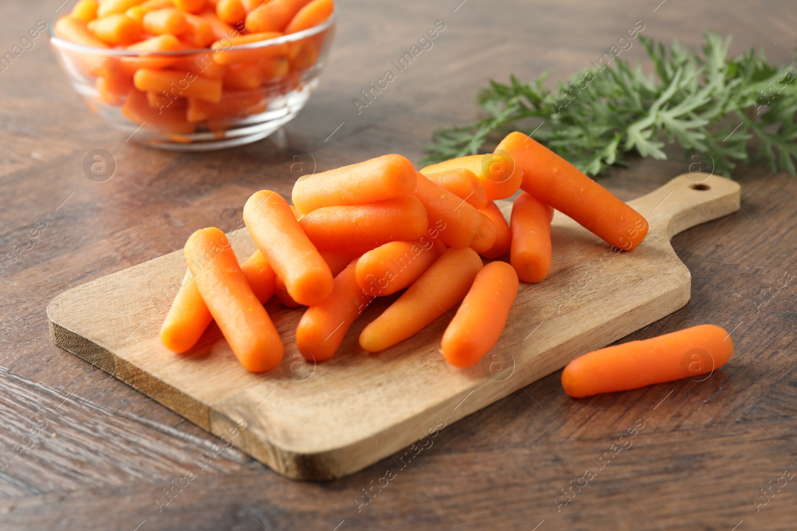 Photo of Baby carrots green leaves on wooden table