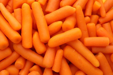 Photo of Many baby carrots as background, top view