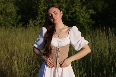 Photo of Beautiful woman in stylish corset posing outdoors