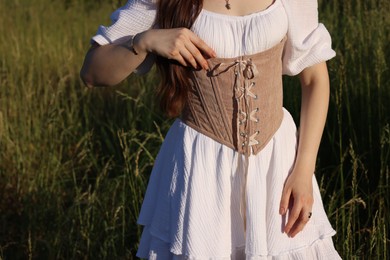 Photo of Woman in velvet ribbon corset outdoors, closeup