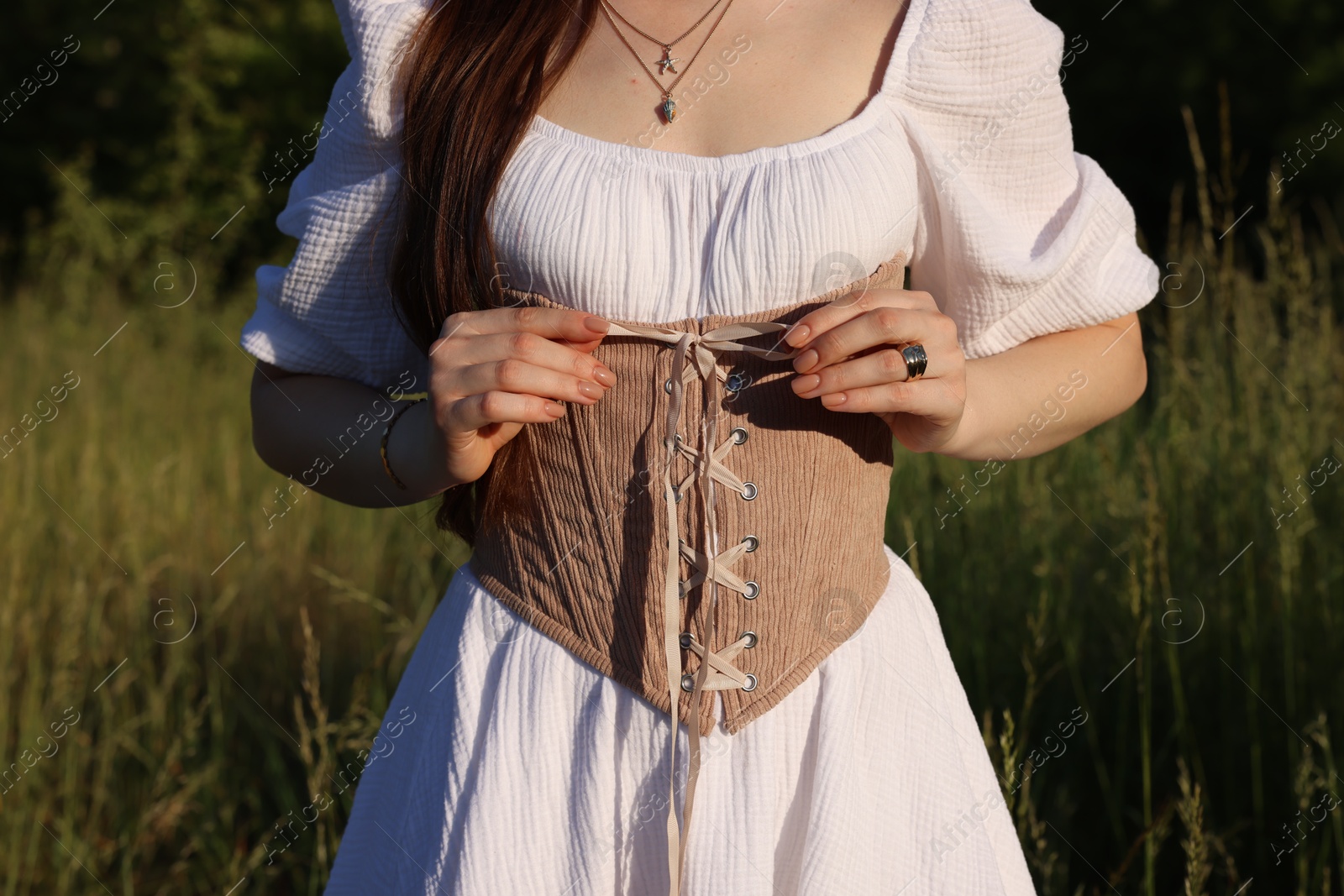 Photo of Woman in velvet ribbon corset outdoors, closeup